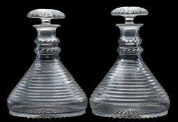 A pair of cut glass ship's decanters and stoppers with double knopped stems and on star cut bases,