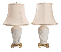 A pair of biscuit ceramic and gilt metal mounted vase table lamps,