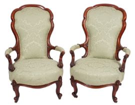 A pair of Victorian walnut and upholstered open armchairs,