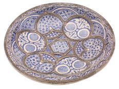 A Moroccan metal-mounted blue and white dish decorated with Moorish abstract motifs within filigree