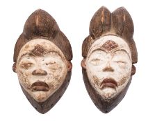 Two Panu (Gabon) carved wooden female masks each with elaborate domed hair,