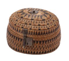 An East Indies oval basket work box and hinged cover decorated with geometric bands,