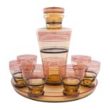 An Art Deco glass cocktail set, of pale amber colour with red and black banded decoration,