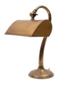 A brass desk lamp, early 20th century; with electrical fitment within an adjustable shade,