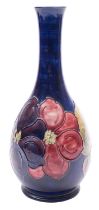 A Walter Moorcroft vase, of tear drop form tube lined in the Clematis pattern on a blue ground,