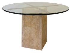 A glass topped and stone dining or centre table, modern; the round top on cruciform metal bearers,