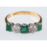 An emerald and diamond ring, the three square cut emeralds with old brilliant cut diamonds,