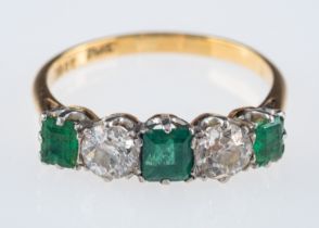 An emerald and diamond ring, the three square cut emeralds with old brilliant cut diamonds,