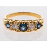 A sapphire & diamond five stone ring in carved 18ct yellow gold mount, sapphires are mid blue,