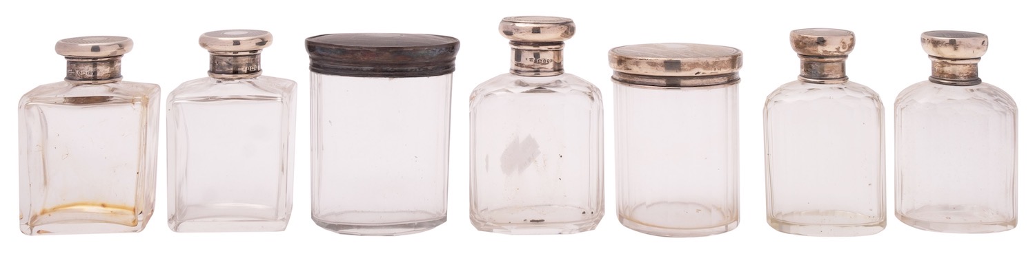 Seven various silver lidded glass bottles and jars,