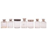 Seven various silver lidded glass bottles and jars,