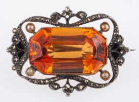 An Edwardian brooch set with a step cut orange topaz stone,