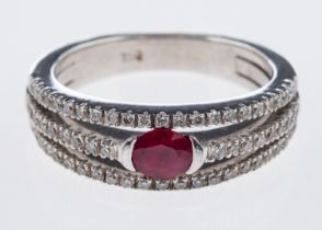 A diamond and ruby ring the central oval faceted stone with split band in 18ct white gold
