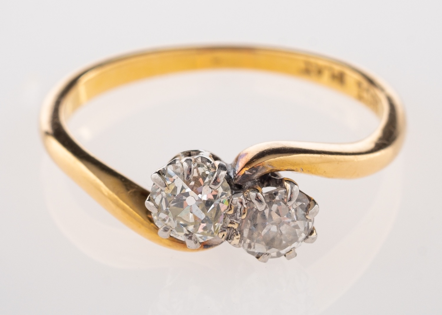 A two stone diamond ring, claw set with two old mine diamonds, in an 18ct and platinum mount.