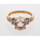 A pale peach coloured morganite ring with white sapphire set shoulders.