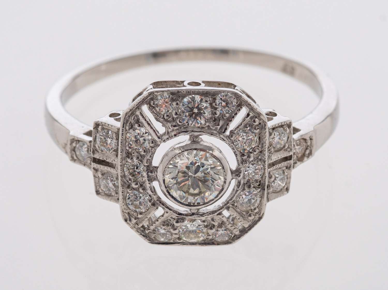 A platinum openwork set plaque ring in millgrain setting, centre stone estimated at 0.