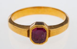 A ruby single stone ring in high carat gold, rub-over setting with closed back, weight 3.