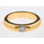 A heavy gold band ring single stone diamond ring inset with a diamond of 0.