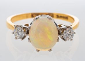 An opal and diamond ring in yellow gold, total diamond weight estimated at 0.