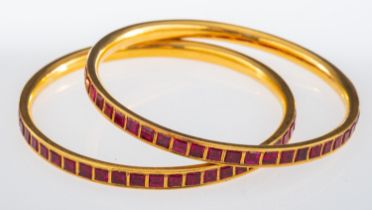 Two Indian high carat gold bangles set with square cut rubies, interior measurement, 6.