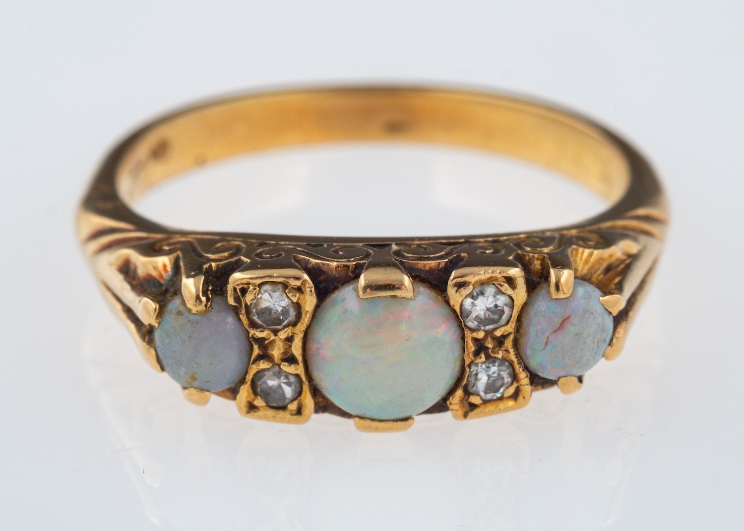 An opal and diamond ring, the three circular cabochon opals with eight cut diamonds in between,
