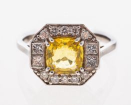 A plaque ring of octagonal form set with a yellow sapphire within a border of brilliant cut