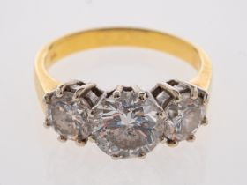 An 18ct gold diamond three stone ring, the central brilliant cut diamond, estimated to weigh 1.