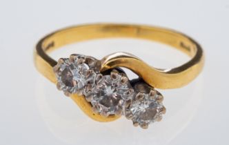 A three stone diamond ring, set with brilliant cut diamonds in crossover design mount, 18ct gold,