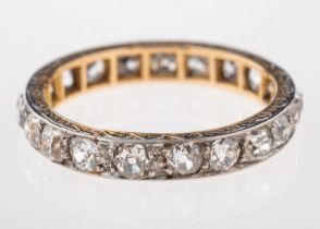 A diamond eternity ring, set with old cut diamonds, with an engraved border,