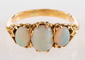 A three stone opal ring, set with three oval cabochon opals in claw settings, ring size O 1/2.