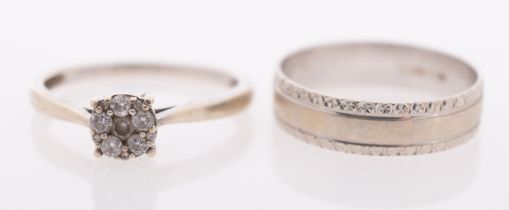 Two white gold rings, a diamond cluster ring, and a gold band with relief decoration, both 9ct gold,