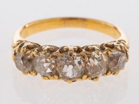 A fine Victorian five stone ring, old cut diamonds in carved mount with small fleur de lys emblems,