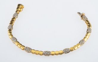 A bracelet of articulated links in 18ct yellow gold interspersed with diamond set plaques in white