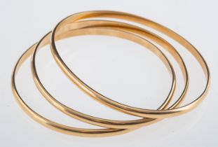 Three yellow metal D form bangles, testing as 9ct gold, internal measurement 6cm, weight 34.