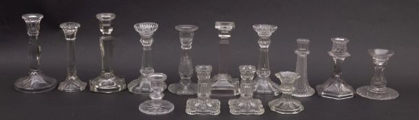 A group of pressed glass candlesticks.