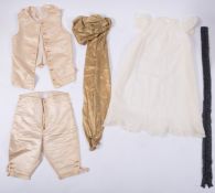 A collection of child's clothing items including a floral silk jacket with hand-worked lace cuffs,