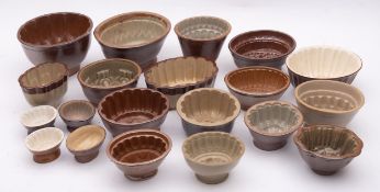A collection of brown glaze earthenware jelly moulds, various sizes and patterns,