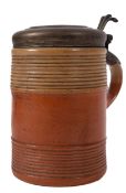 An 18th century lidded pottery tankard, the cover dated 1742, over a ribbed body,
