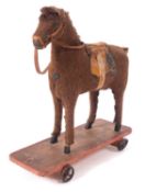 A late 19th/ early 20th century pull along horse, the brown fabric horse with boot button eyes,