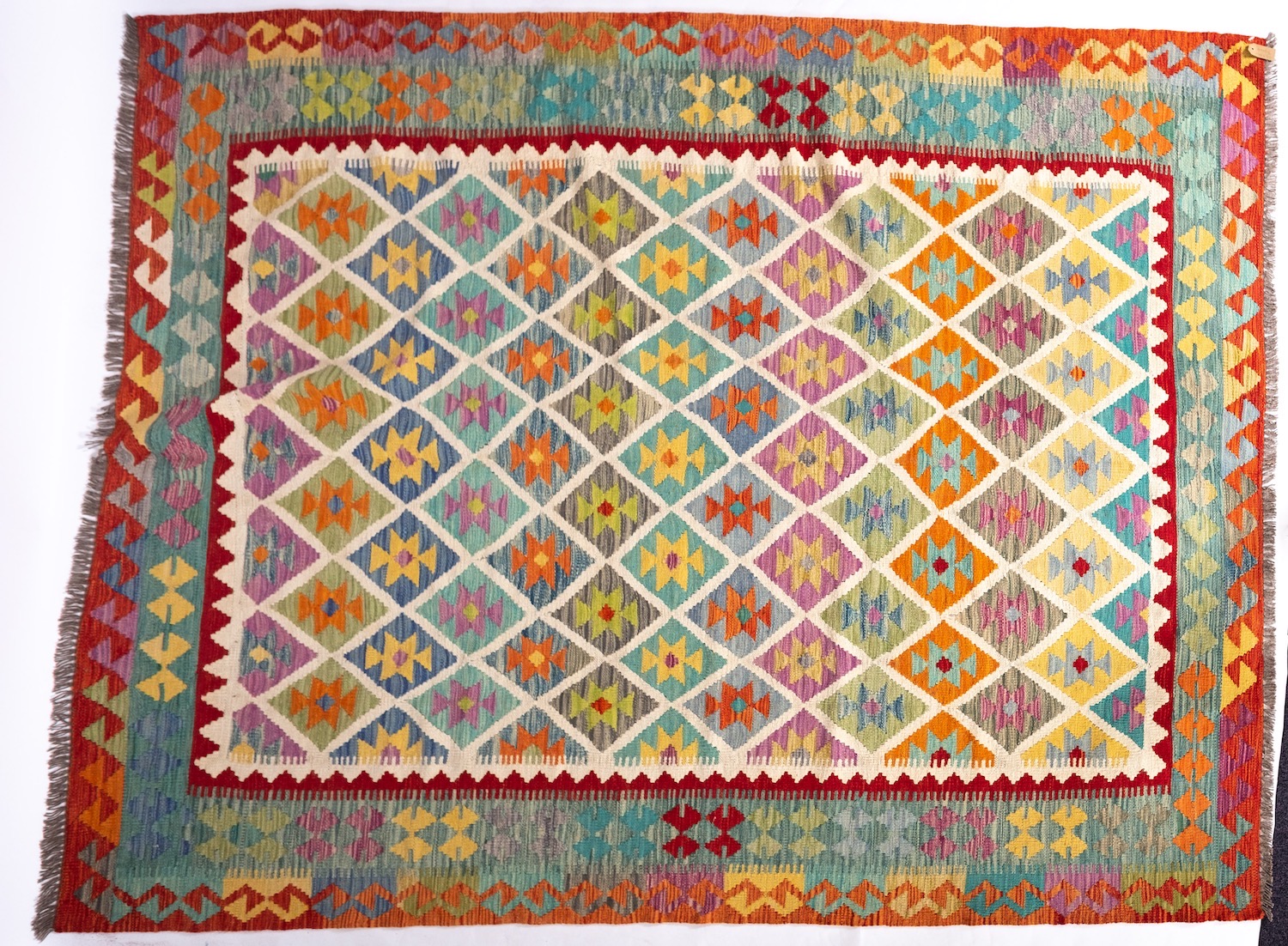 An Anatolian Turkish Kilim, the brightly coloured lozenge field in a variety of pastel shades,