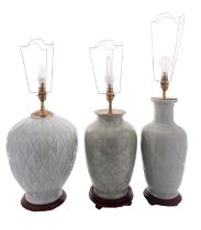 A group of three Chinese-style celadon glazed table lamps with wood stands and fittings,