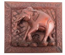 A carved and stained hardwood relief modelled with an elephant, probably South East Asian,