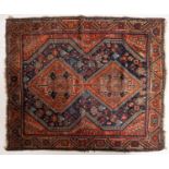 A Hamadan rug, the indigo field with twin brown serrated lozenge medallions,