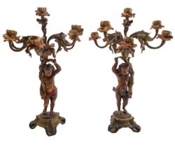 A pair of bronze and later cold painted figural six light candelabra,