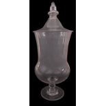 A large clear glass apothecary jar and cover with acorn finial and on single knopped stem,