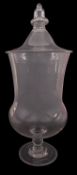 A large clear glass apothecary jar and cover with acorn finial and on single knopped stem,