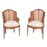 A pair of carved mahogany and caneworked bergere chairs, in Louis XVI style,