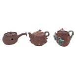 A group of three small Chinese Yixing teapots and covers one in the form of a lotus seed pod,