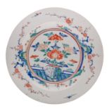 A large Japanese Kakiemon-style charger painted in bright enamels with rockwork, a fence,