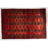 A Turkoman rug, the rose field with three rows of quartered guls,